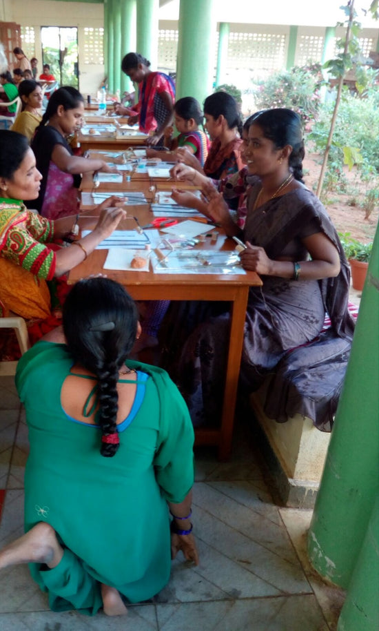 Mujeres en riesgo de exclusión social  de India confeccionando pulseras Dkary